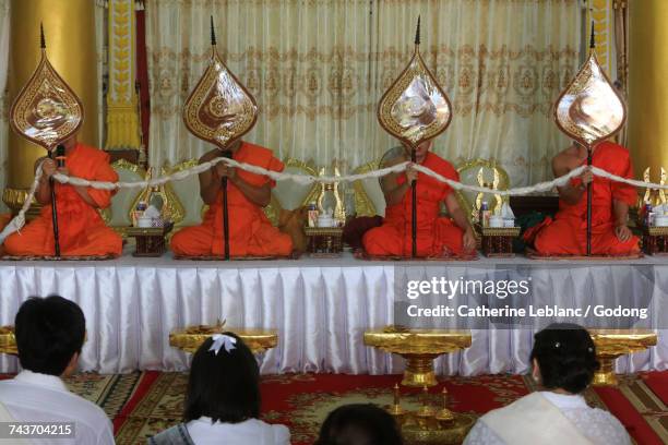 seated buddhist monks praying at a buddhist ceremony. remembrance of the deceased. wat ong teu mahawihan. temple of the heavy buddha. vientiane. laos.  laos. - temple wat ong teu photos et images de collection