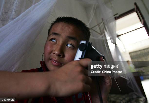 Thirteen-year-old blind child Chen Zhe listens to a wireless in a dormitory of the Wuhan School for the Blind on May 31, 2007 in Wuhan of Hubei...