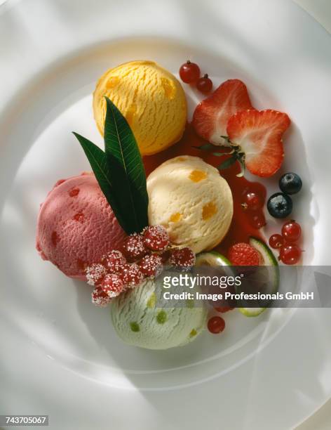 plate of assorted ice cream with summerfruit coulis - cassis fruit stock-fotos und bilder