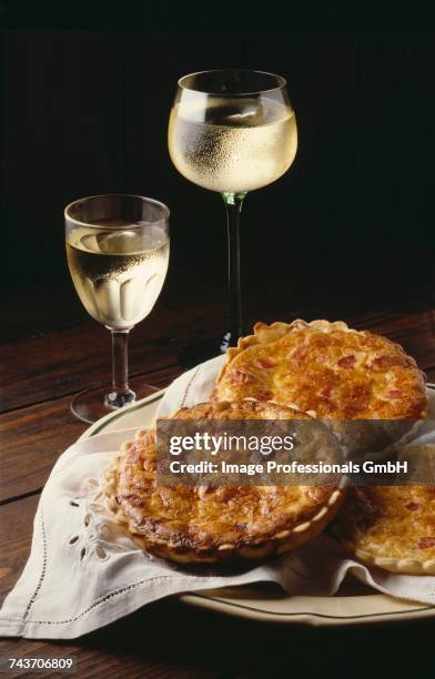 individual quiches and two glasses of white wine - mini quiche stock pictures, royalty-free photos & images