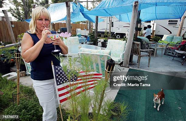 Debbie Coleman, who rode out Hurricane Katrina on a boat, sips a margarita at the slab where her destroyed home sat on the official first day of...