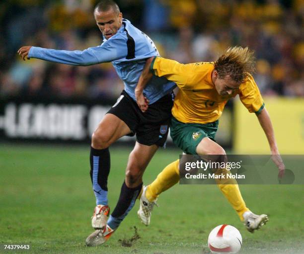 Guillermo Giacomazzi of Uruguay tackles Ryan Griffiths of Australia during the International Friendly match between Australia and Uruguay at Telstra...