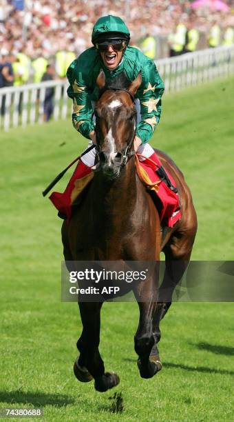 Epsom, UNITED KINGDOM: Jockey Frankie Detorri crosses the finish line to win the Vodafone Derby with Irish horse Authorized on the second day of the...