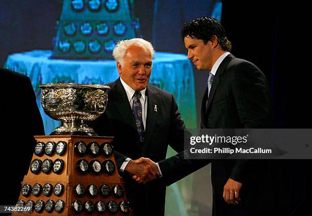 Sidney Crosby of the Pittsburgh Penguins poses with the Art Ross Trophy as presented by Henri Richard, Hockey Hall of Famer, during the NHL Awards...