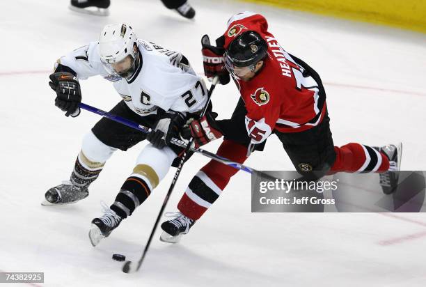 Scott Niedermayer of the Anaheim Ducks collides with Dany Heatley of the Ottawa Senators for possesion of the puck during Game Three of the 2007...