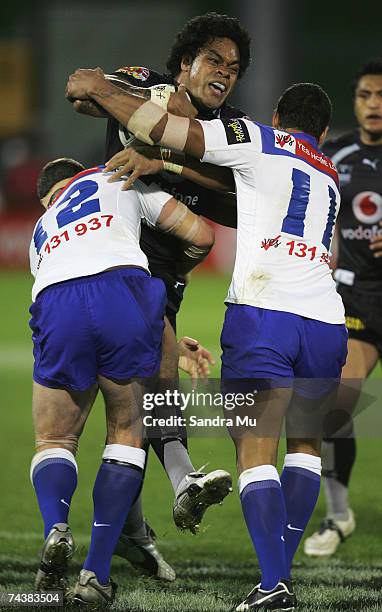 Epalahame Lauaki of the Warriors gets tackled by Andrew Ryan and Lee Te Maari of the Bulldogs during the round 12 NRL match between the Warriors and...