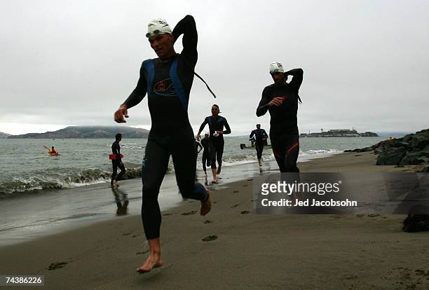 Athletes exit the water after swimming from Alcatraz island during the Escape from Alcatraz Triathlon on June 3, 2007 in San Francisco, California.