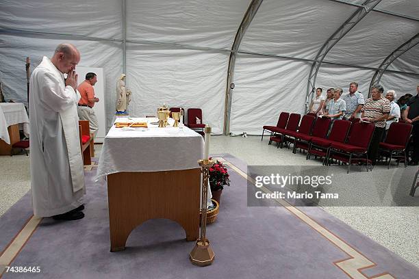 Priest Cuthbert O'Connell leads Sunday Mass at Saint Clare Catholic Church's temporary tent sanctuary June 3, 2007 in Waveland, Mississippi. The...