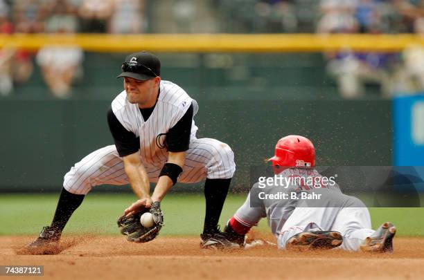Norris Hopper of the Cincinnati Reds reaches second base on a single ahead of a throw to shortstop Jamey Carroll of the Colorado Rockies in the...