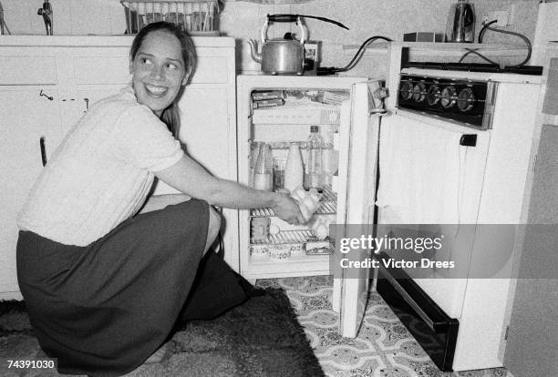 Mrs J Norman stocking the fridge as part of the 'housewife service' she offers from her home in Finsbury Park, London, 11th July 1973.