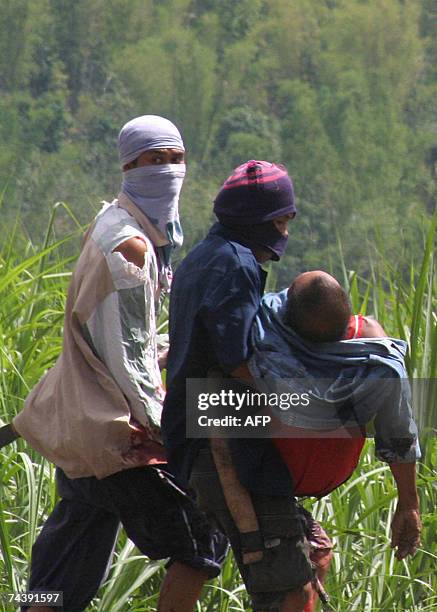 Farmers carry Alejandro Garcesa, seriously bleeding from a gunshot wound 04 June 2007 after private guards of the sugar farm allegedly fired upon the...