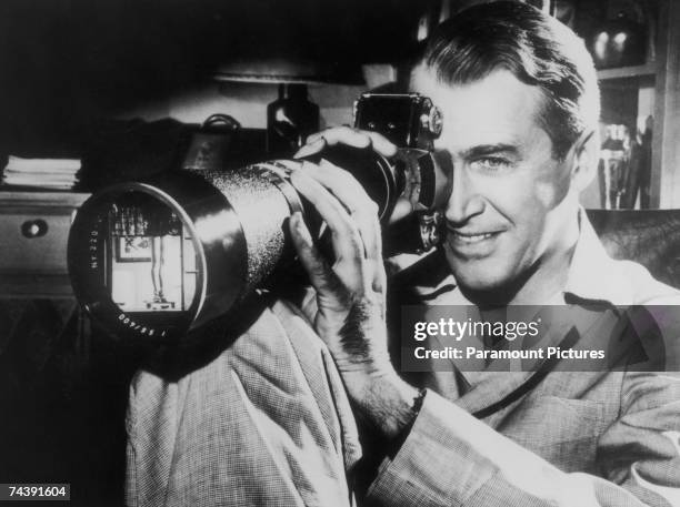 American actor James Stewart focuses on a shapely pair of female legs in a scene from the film 'Rear Window', directed by Alfred Hitchcock for...