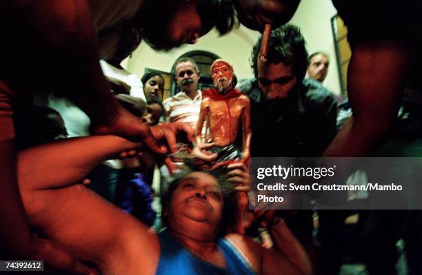 Woman, who has fallen into a trance, is assisted by others during the centuries-old annual pilgrimage to the Iglesia De San Lazaro on the Day Of...