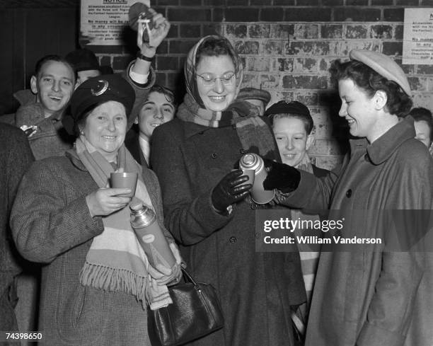 Arsenal fans Mrs H Coogger, Eileen Burrows and Joan Bennett share a flask of coffee while waiting for the cup match against Carlisle at Arsenal's...