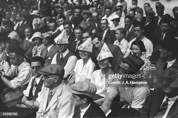 Football supporters wearing newspaper hats to shelter from the sun at Highbury during Arsenal vs Everton, the opening game of the season, 29th August...