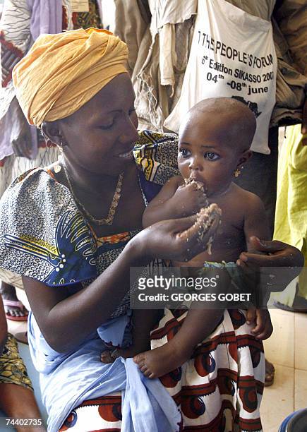 Mother attending the forum to counter the G8 summit of rich states held in Germany feeds her child during a common lunch in the hall of the "Babemba...