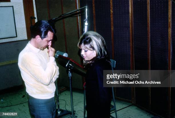 Singer Nancy Sinatra with songwriter and record producer Lee Hazlewood recording in the studio in April 1966.