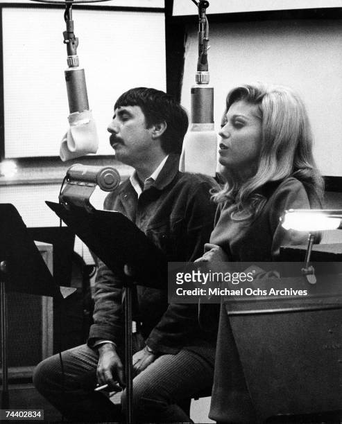 Singer Nancy Sinatra with songwriter and record producer Lee Hazlewood recording in the studio circa 1966.