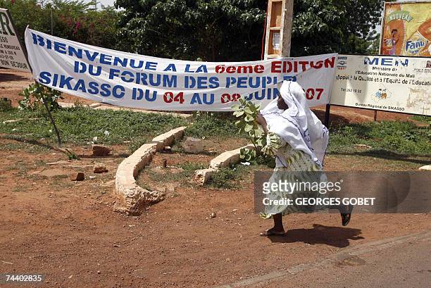 Young woman walks past a banner annoncing the forum to counter the G8 summit of rich states held in Germany near the "Babemba Traore" stadium in...