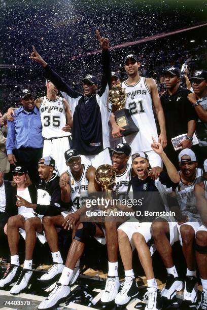 The San Antonio Spurs and assistant coach Mike Brown pose for a portrait with the champianship trophy after Game Six of the 2003 NBA Finals against...