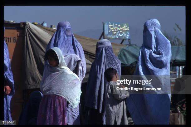 Veiled women stand in the street October 11, 1996 in Kabul, Afghanistan. The Taliban army faces opposition by the guerrillas of Ahmas Shah Masoud,...