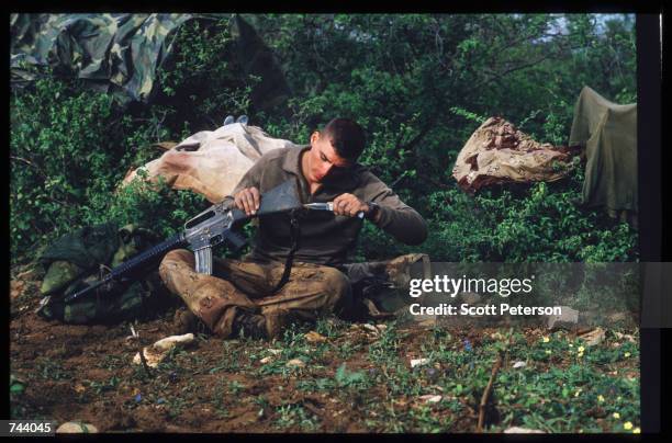 Marine cleans a gun while on a peacekeeping mission December 17, 1992 in Baidoa, Somalia. From August to November 1992, an estimated 21,000 of...