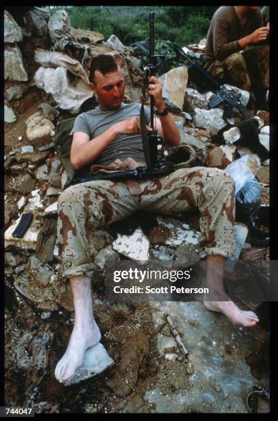 Marine performs maintenance on a gun while on a peacekeeping mission December 17, 1992 in Baidoa, Somalia. From August to November 1992, an estimated...