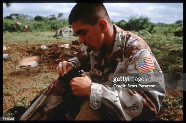 Marine handles a gun while on a peacekeeping mission December 17, 1992 in Baidoa, Somalia. From August to November 1992, an estimated 21,000 of...