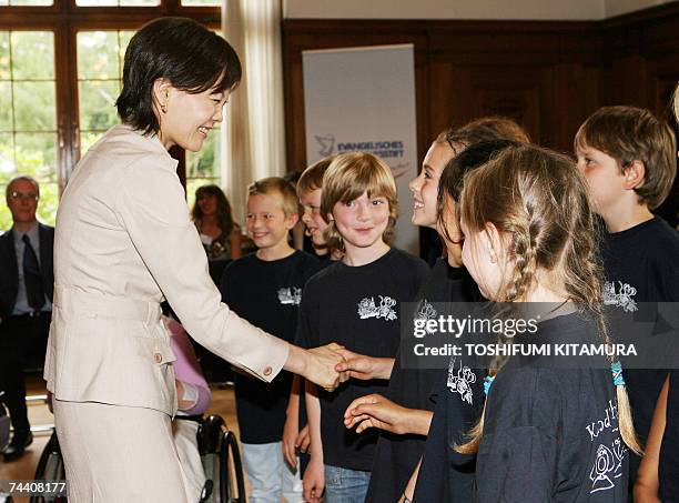 Akie Abe, wife of Japanese Prime Minister Shinzo Abe, shakes hands with children while visiting the Evanghelisches Johannesstift, one of the oldest...