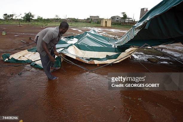 Man collects debris after a strong storm destroyed food tents installed near the "Babemba Traore" stadium in Sikasso, Mali, for a forum to counter...