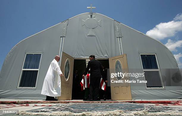 Priest Cuthbert O'Connell watches as pallbearers move the casket of U.S. Army World War II veteran Edward Cook after his funeral in Saint Clare...