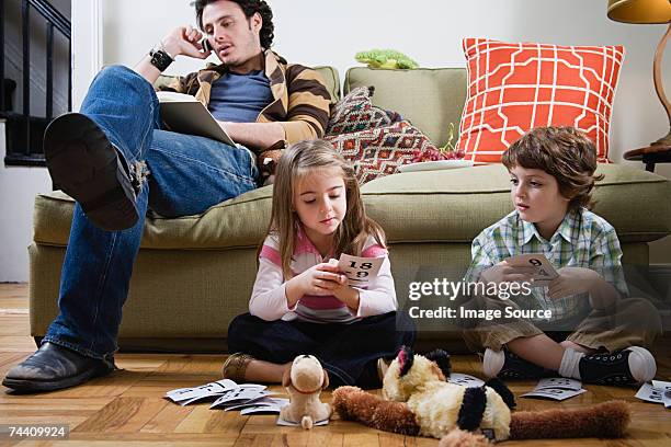 father on cell phone as kids play - stupid stock pictures, royalty-free photos & images