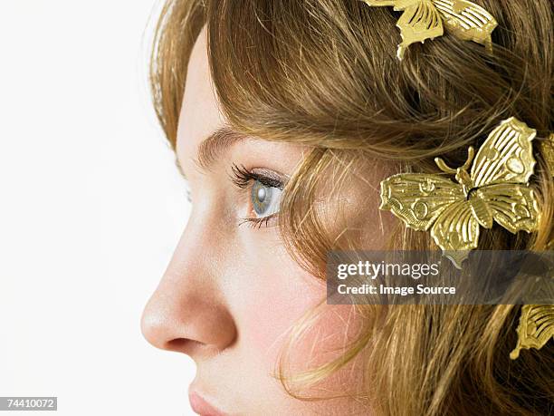 woman with gold butterflies in her hair - human nose stockfoto's en -beelden