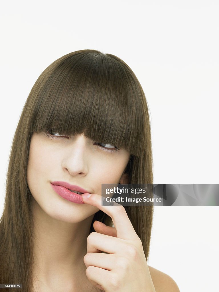 Young woman touching her lip