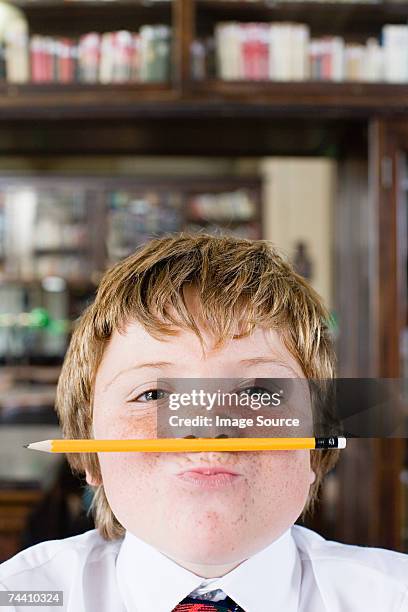 boy with pencil under his nose - naughty kids in classroom stock pictures, royalty-free photos & images