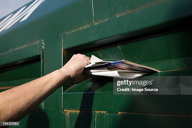 person putting paper into paper bank - holding magazine stock-fotos und bilder