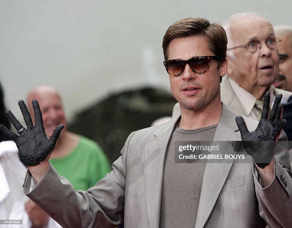 Actor Brad Pitt shows off his hands after immortalizing his prints in