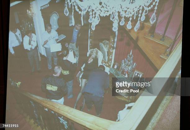 Photograph is projected as evidence detailing the view from the stairs in the foyer of Phil Spector's house, where investigators gathered around the...