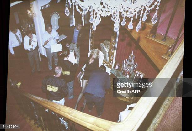 Los Angeles, UNITED STATES: An evidence photograph taken from the stairs in the foyer of Phil Spector?s house showing investigators around the body...