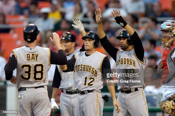 Jason Bay of the Pittsburgh Pirates is congratulated by Freddy Sanchez and Jose Bautista after they all scored on a double by Xavier Nady in the...