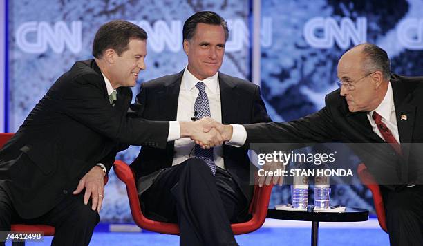 Manchester, UNITED STATES: Kansas Senator Sam Brownback shakes hands with former New York City mayor Rudy Giuliani in front of former Massachusetts...