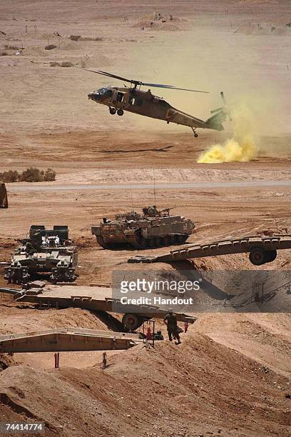In this handout photo distributed by the Israel Defense Forces helicopters and tanks are mobilized as the Israeli army takes part in a military...
