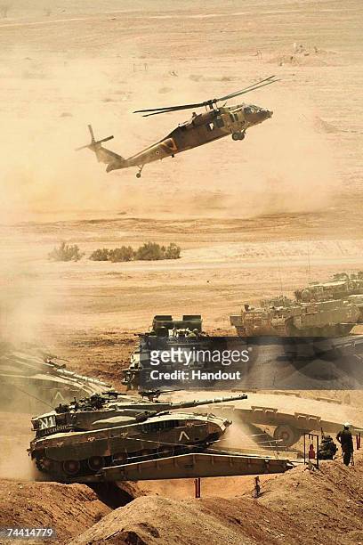 In this handout photo distributed by the Israel Defense Forces helicopters and tanks are mobilized as the Israeli army takes part in a military...