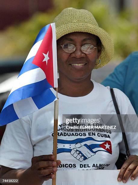 Tegucigalpa, HONDURAS: Una mujer sostiene una bandera cubana durante una manifestacion en apoyo a medicos hondurenos graduados en la Escuela...