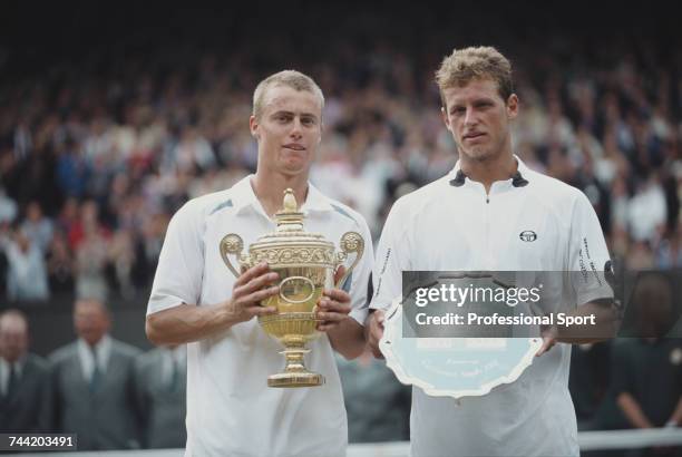 Australian tennis player Lleyton Hewitt holds the Gentlemen's Singles Trophy after beating David Nalbandian of Argentina, 6-1, 6-3, 6-2 in the final...