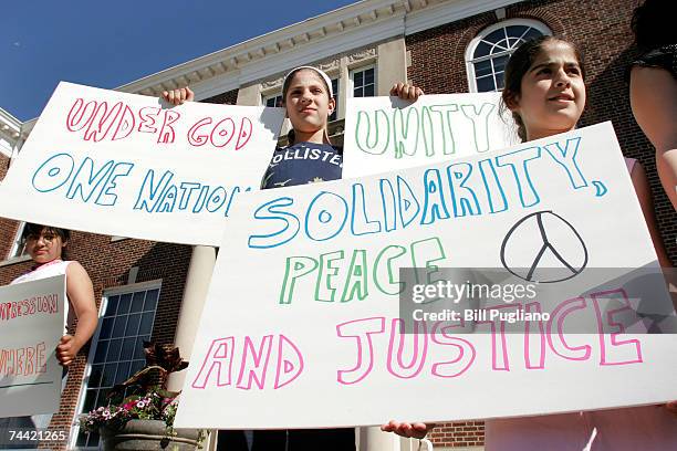 Mariam Sobh , age 10, and her cousin Mirvat Sobh , age 12, both of Dearborn, Michigan, hold signs at a unity rally in front of Dearborn City Hall...
