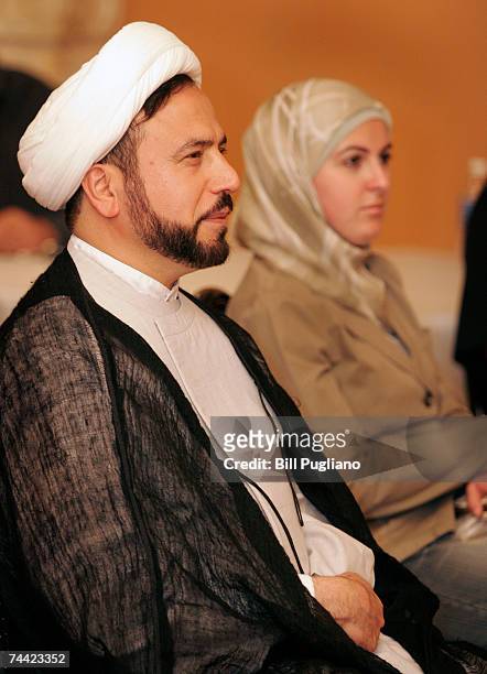 Imam Husham Al-Husainy and Ghazaleh Baydoun of Dearborn, Michigan listen to a speaker during a town hall meeting about Arabic unity at Dearborn City...