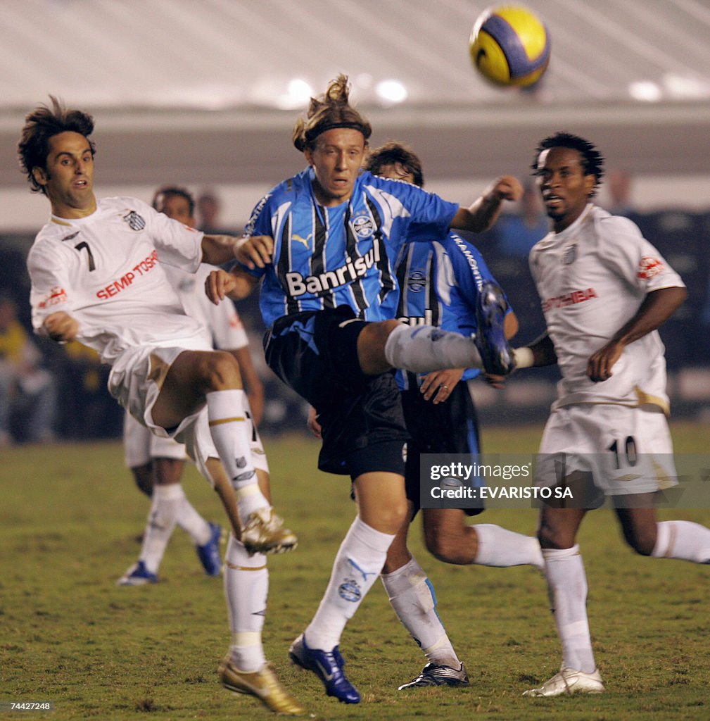 Gremio's Lucas (C) vies with Santos' Jon...