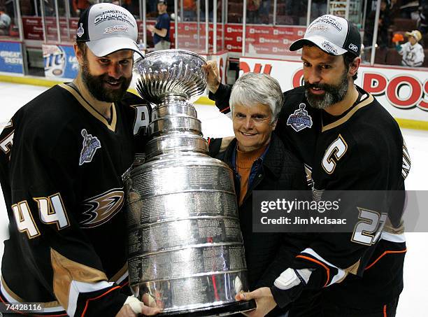 Rob Niedermayer of the Anaheim Ducks and brother Scott Niedermayer pose with their mother Carol and the Stanley Cup after their team's victory over...