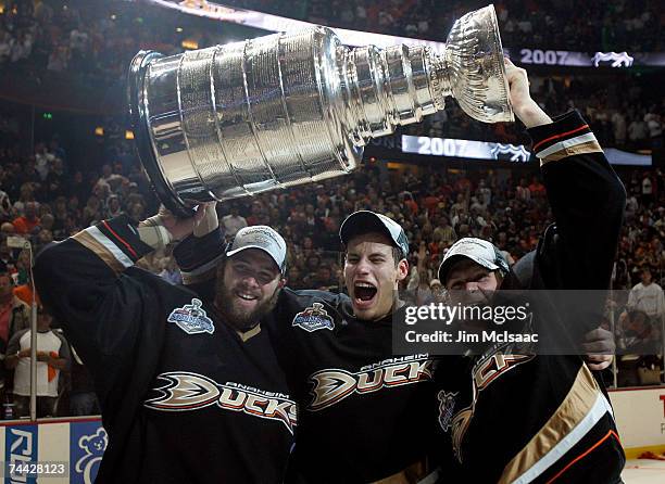 Dustin Penner, Ryan Getzlaf and Corey Perry of the Anaheim Ducks celebrate lifting the Stanley Cup after defeating the Ottawa Senators in Game Five...